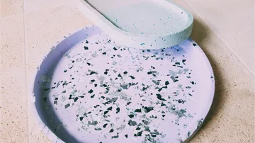 Terrazzo-Tablett und Schale auf Fliesenoberfläche.