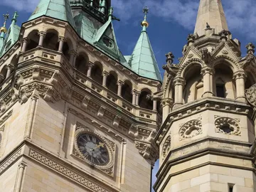 Tower with clock shows time under a blue sky.