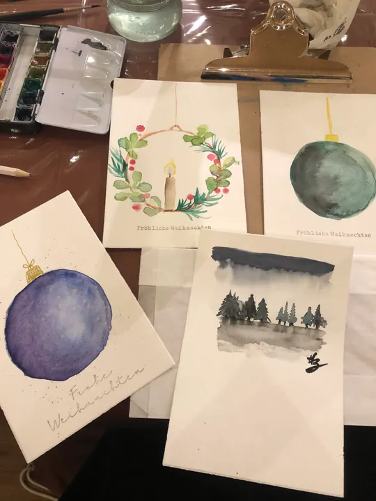Vier gemalte Weihnachtskarten mit Dekorationen.
