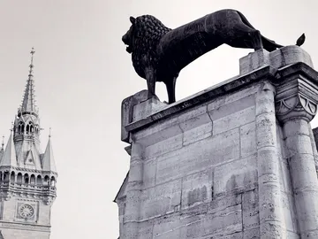 Lion stands majestically on a monumental pedestal.