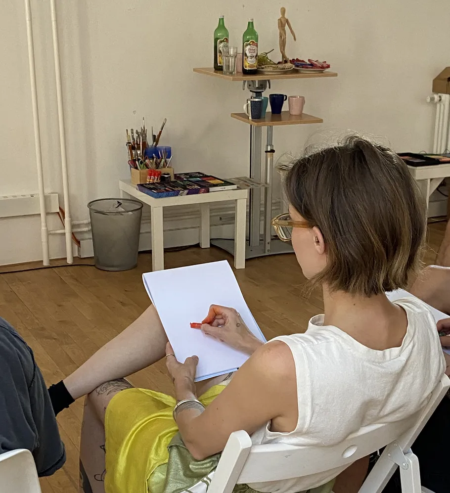 Woman sketching in art studio environment.