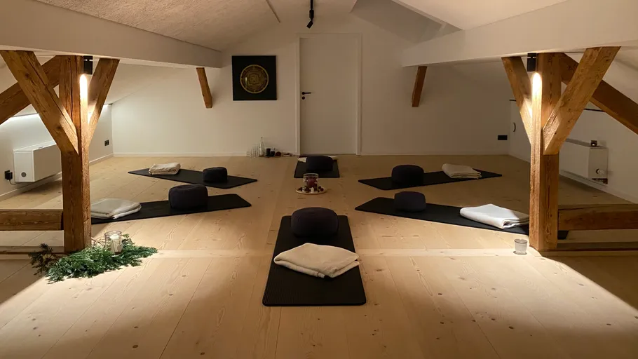 Meditationskissen auf Matten in ruhigem Raum.