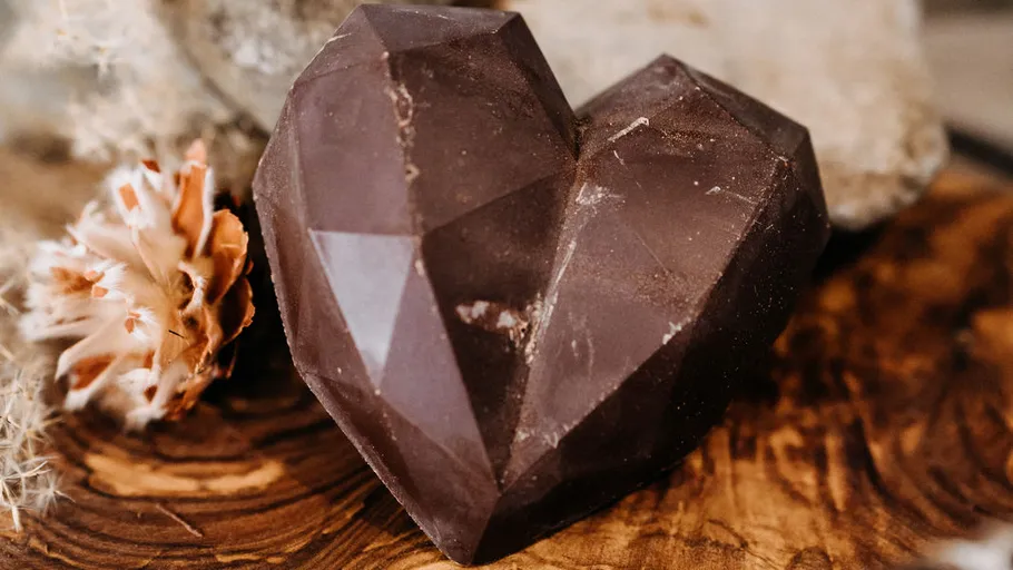 Geometric chocolate heart on wooden surface.