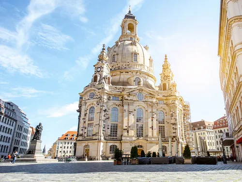 A large church stands on the square in sunlight.