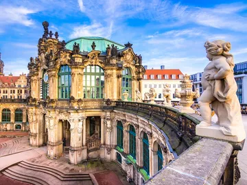 Historic building with sculptures surrounded by blue skies.