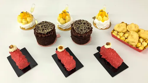 Verschiedene Desserts auf weißer Fläche arrangiert.