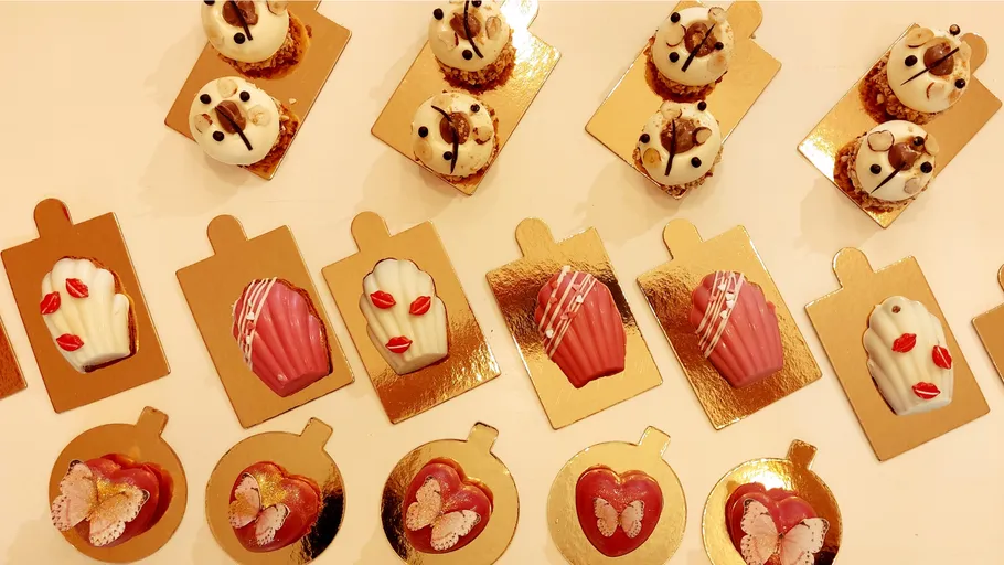 Decorative desserts on shiny gold trays.