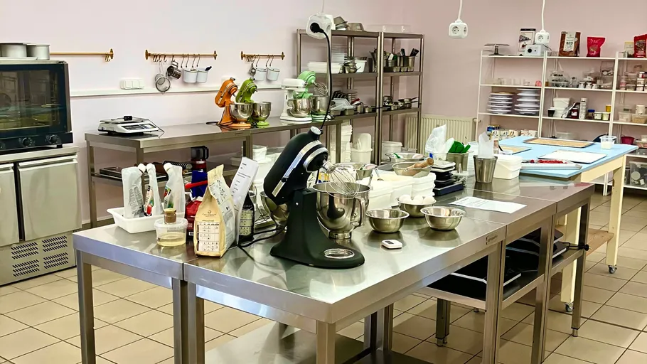 Industrial kitchen with mixers on metal tables.