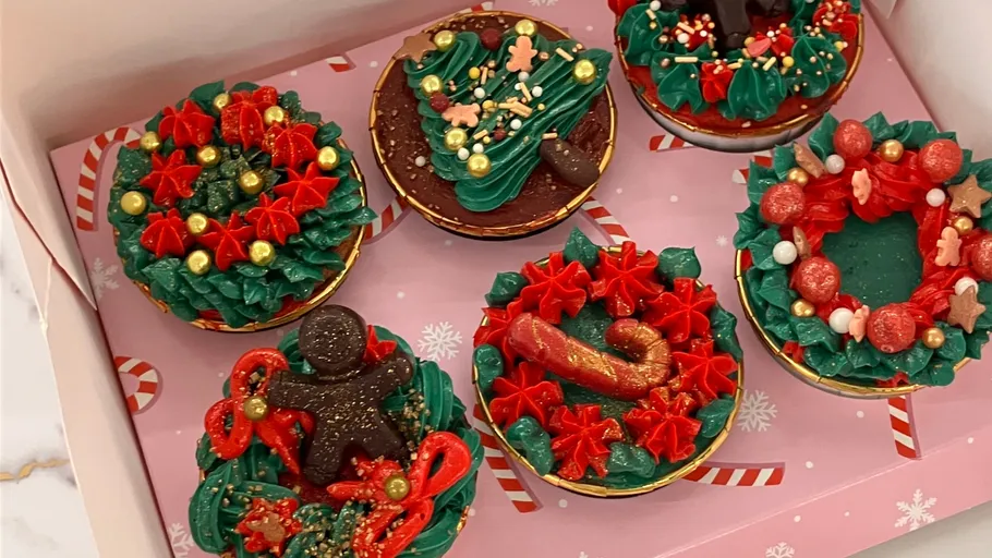 Festliche Cupcakes mit roten und grünen Dekorationen.