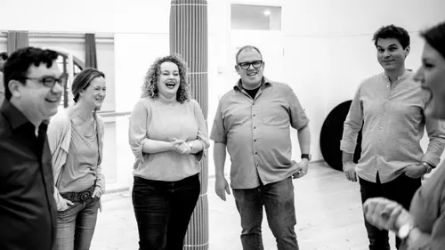 Group of people laughing in a room.