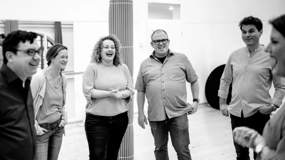 Group of people laughing in a room.