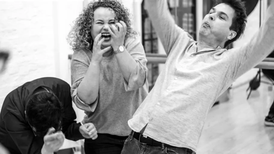 Drei Personen lachen in einem Tanzstudio.