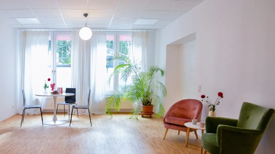 Bright room with chairs, table, and plants.