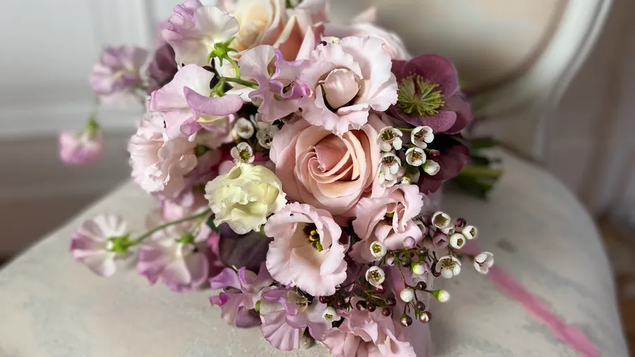 Pink bouquet with roses on a chair.