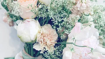 Bouquet of pastel flowers with greenery.