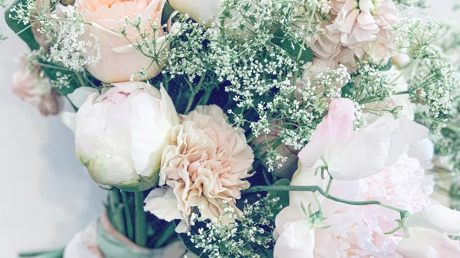 Strauß aus pastellfarbenen Blumen mit Grün.