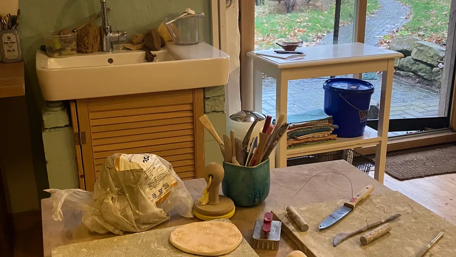 Pottery tools and materials in a studio.