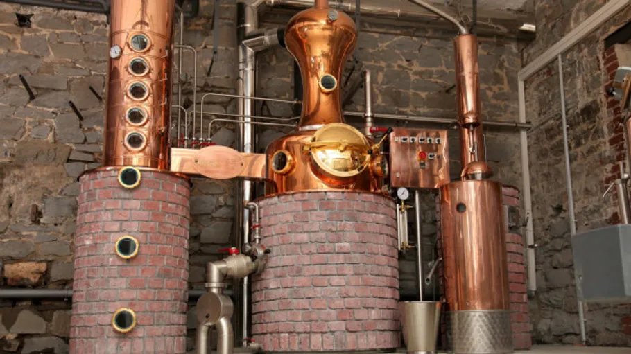Copper distillation equipment in a stone room.