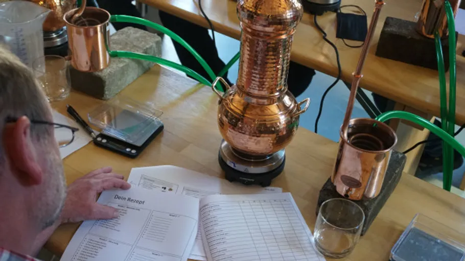 Man reading recipe beside copper distiller.