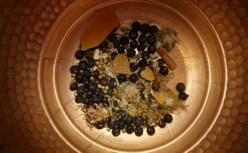 Dried botanicals in copper pot viewed from above.