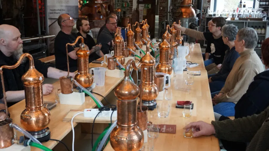 People attending a distilling workshop with copper stills.