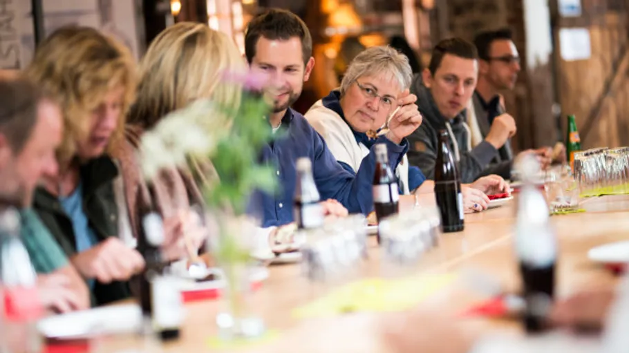 People sitting at a long table, talking.