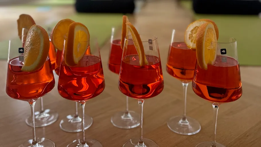 Glasses of orange cocktails on wooden table.