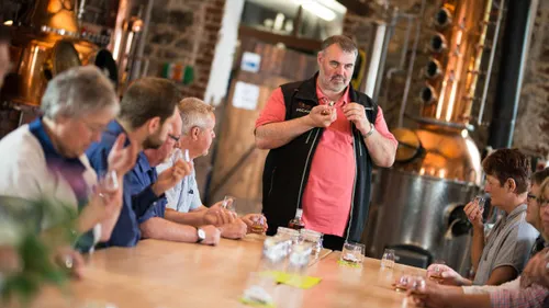 People tasting spirits in a distillery.