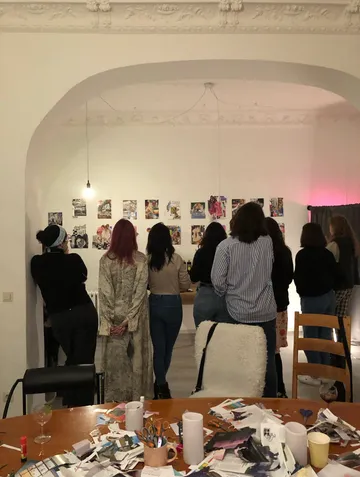 Group examining wall art in a studio.