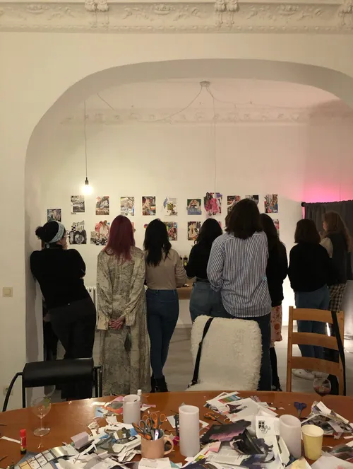 Group examining wall art in a studio.