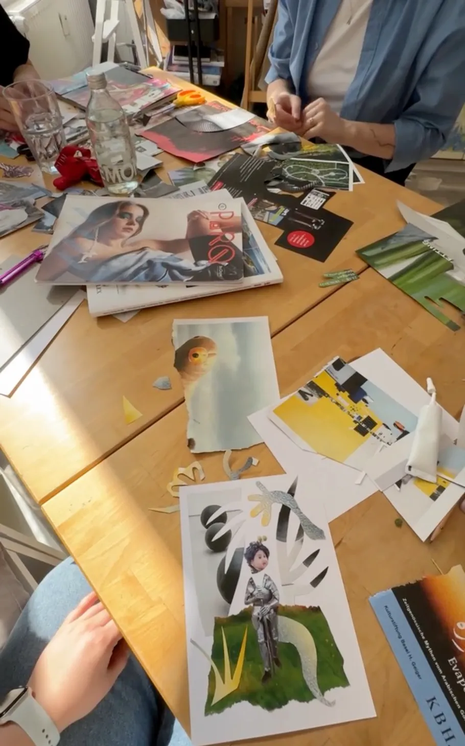 People making collages at a wooden table.