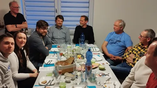 Gruppe von Personen am Esstisch sitzend.