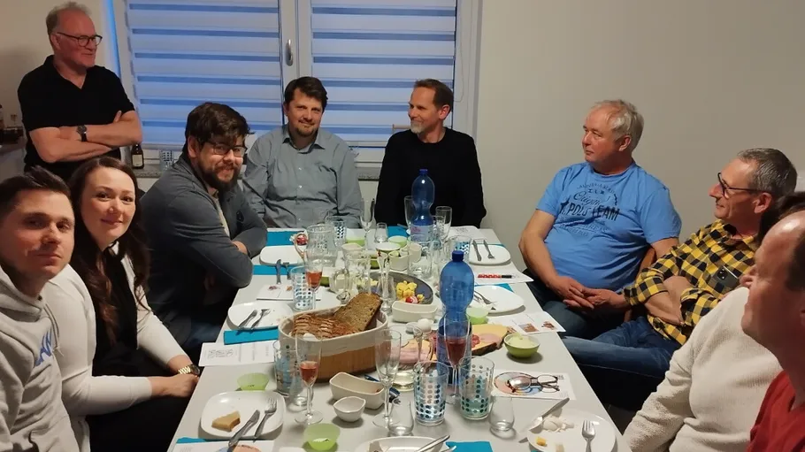 Gruppe von Personen am Esstisch sitzend.