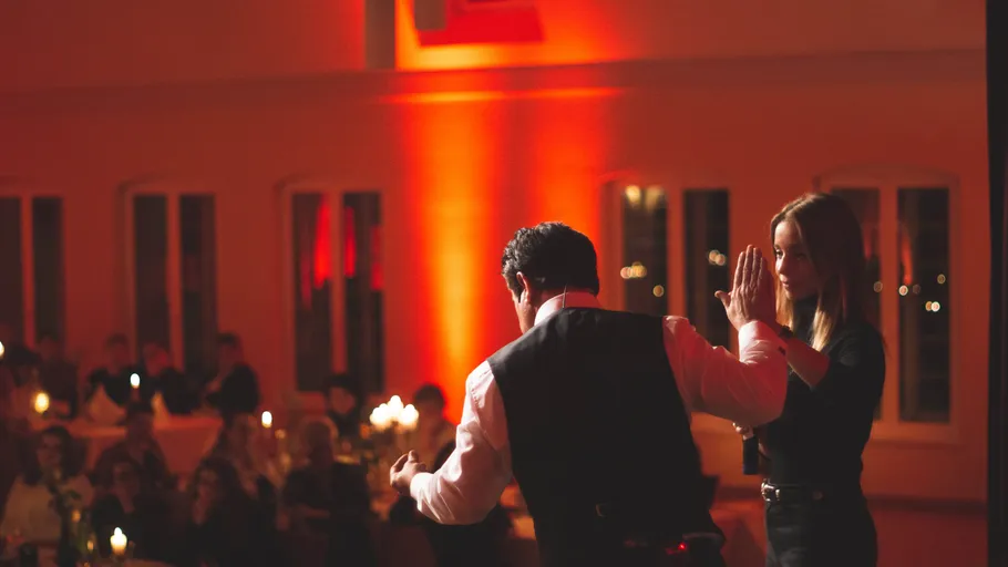 Zwei Personen tanzen auf der Bühne bei Veranstaltung.