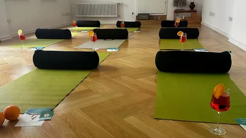 Yoga mats with drinks and pillows on floor.
