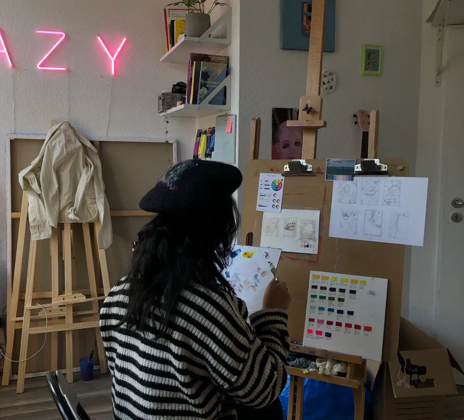 Artist painting in a cozy studio setting.