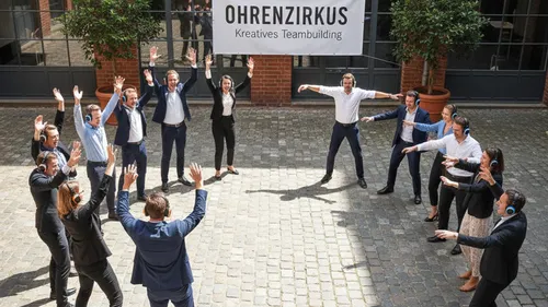 Gruppe mit Kopfhörern bei Teambuilding im Freien.