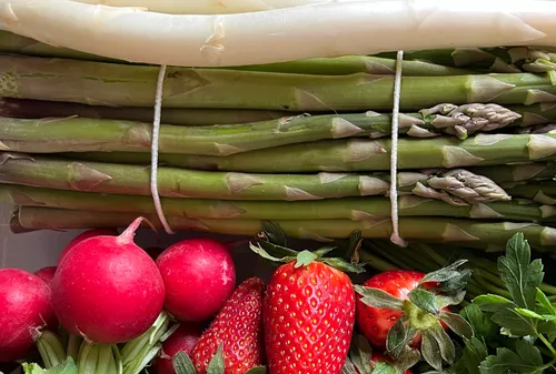 Asparagus, radishes, and strawberries on display.