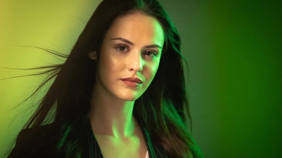 Woman with long hair, green lighting.