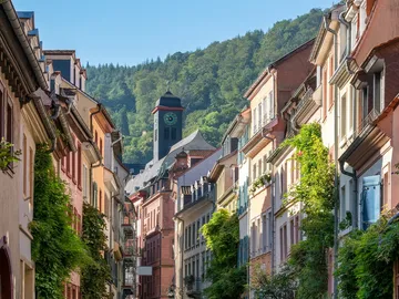 Bottleneck with colorful houses, clock tower in the background, mountains.
