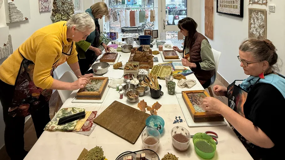 People crafting at a table in studio.