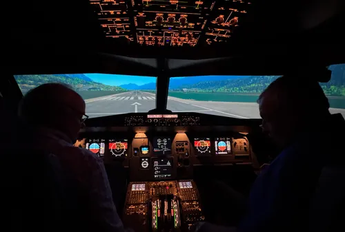 Zwei Personen im Cockpit eines Flugsimulators.