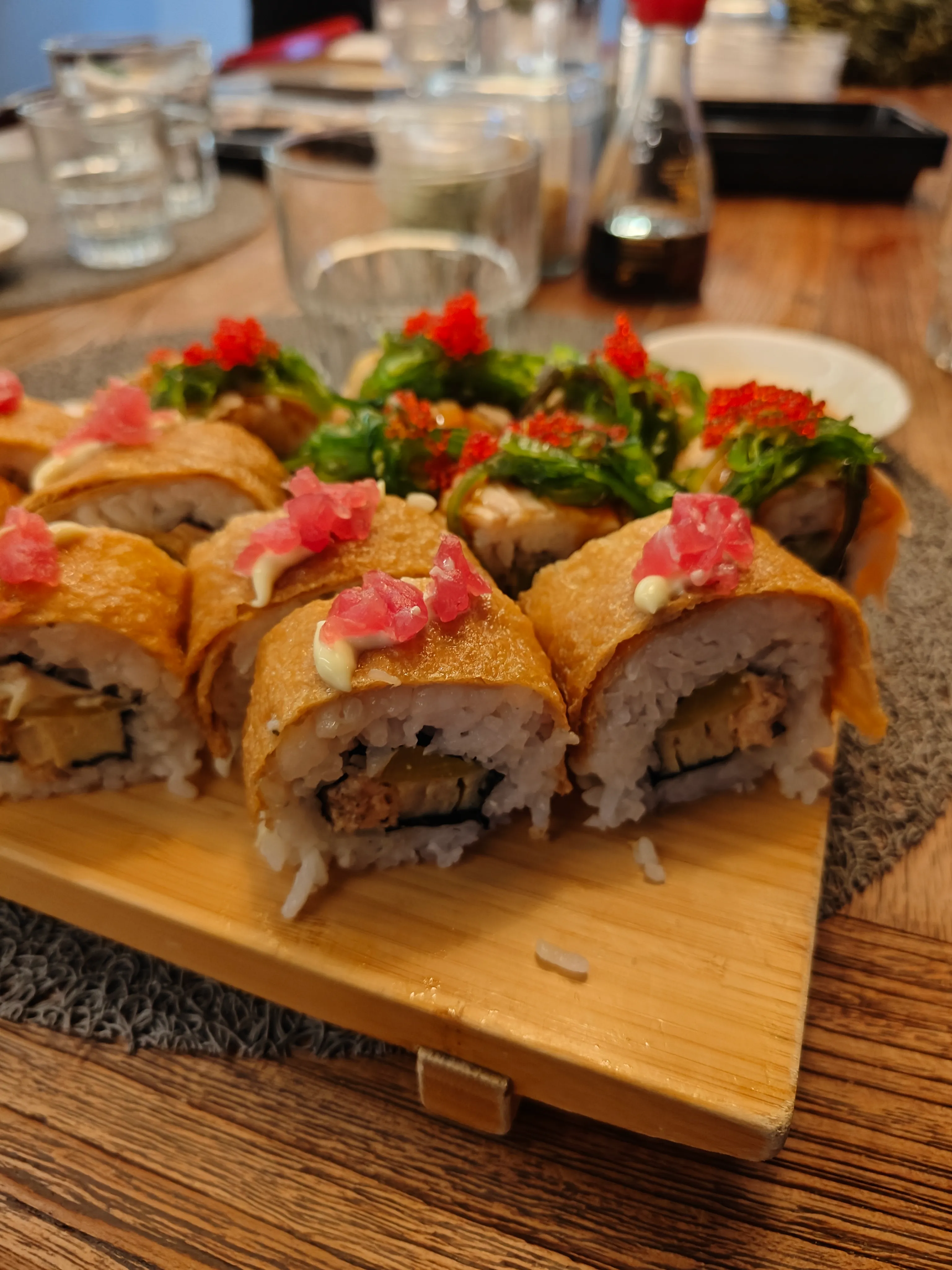 Sushirollen auf Holzbrett, Esstisch-Szene.