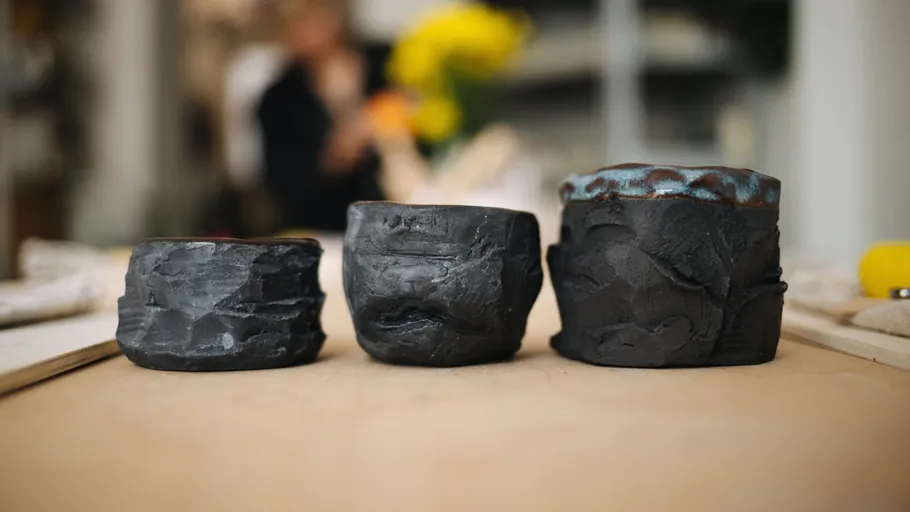 Drei strukturierte Keramikbecher auf einem Tisch.