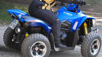 Blue quad bike on dirt track.