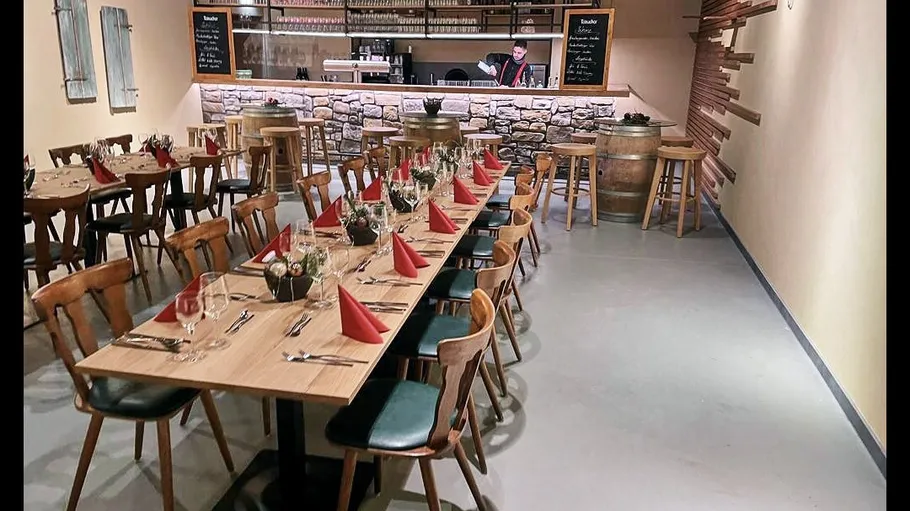 Restaurant with arranged tables, bartender in background.
