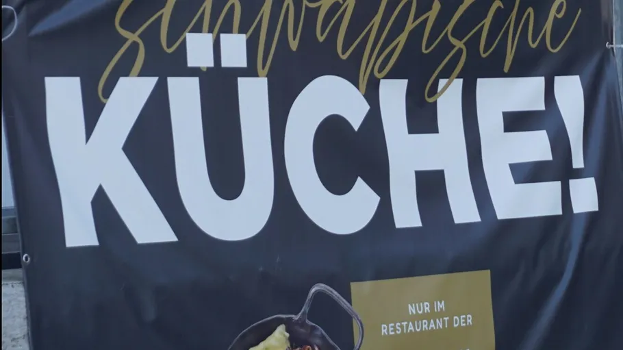 Banner wirbt für schwäbische Küche im Freien.