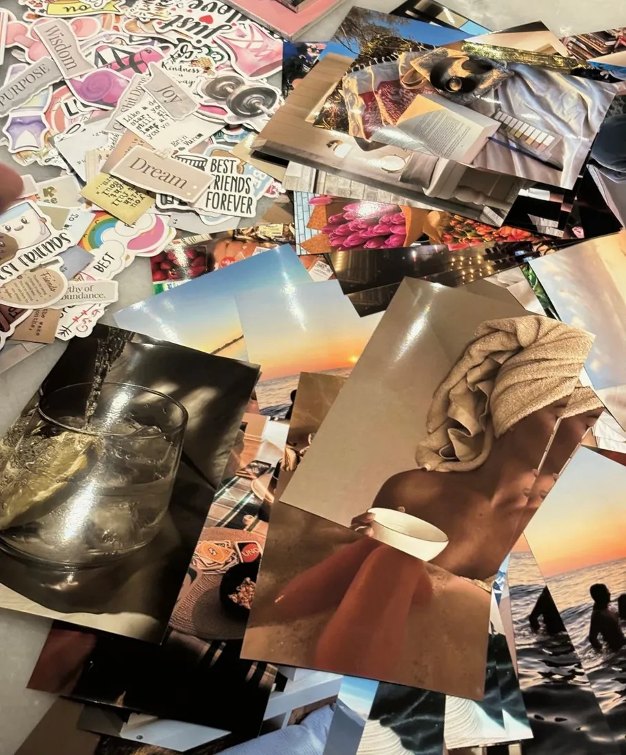 Sammlung von Fotos und motivierenden Stickern auf Tisch.