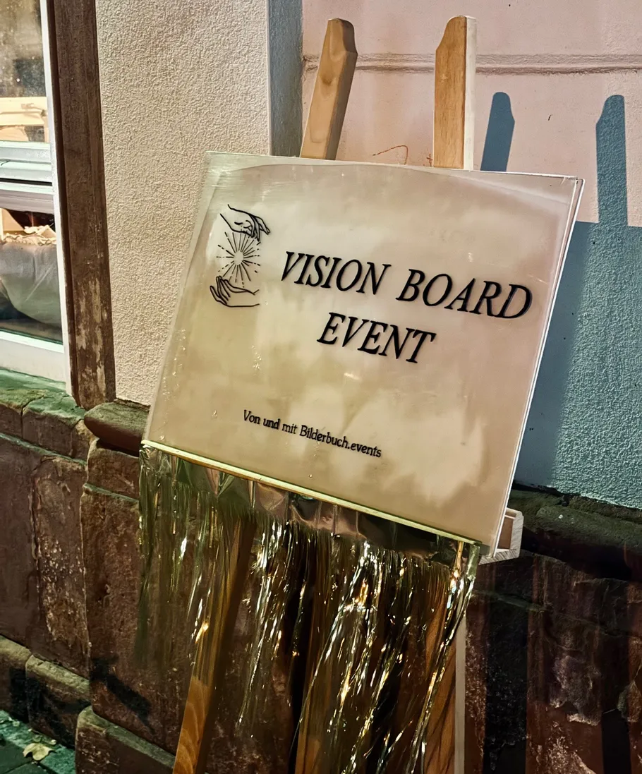 Schild wirbt für Vision Board Event draußen.