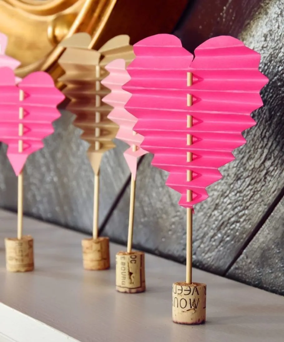 Paper heart decorations on cork bases, indoors.